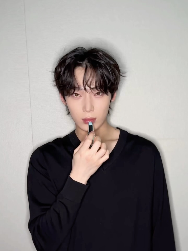 ENHYPEN's Sunoo in a promotional image for Prada Beauty, featuring a blue heart and lipstick emoji.