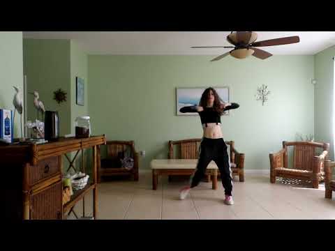 A person dancing in a dimly lit studio, performing a K-pop dance cover of IVE's 'BLACKHOLE'.