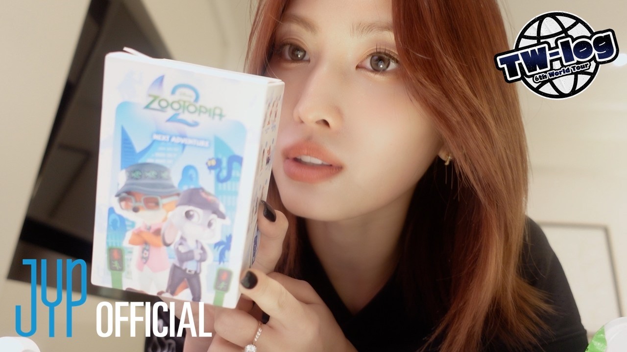 TWICE's Momo in a performance outfit, smiling on stage, from the 6th World Tour 'THIS IS FOR' TW-LOG episode