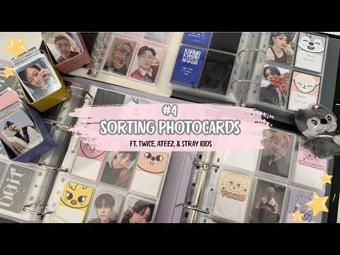 A collection of K-pop photocards being sorted, featuring cards from TWICE, ATEEZ, and Stray Kids.