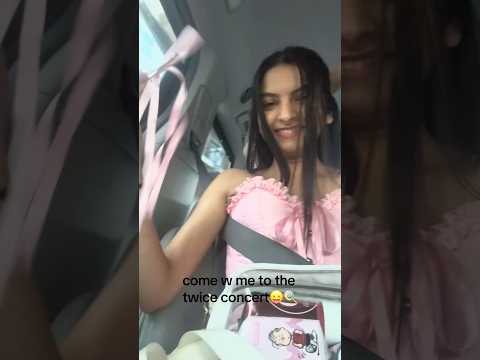 A blurry image of a concert stage with lights, likely from a fan's perspective at a TWICE K-pop concert.